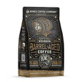 The front of a 12 ounce bag of Bones Coffee Company Bourbon Barrel Aged coffee. There is a barrel with the Bones Coffee Company skull logo on it on the art.