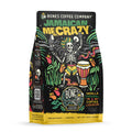 The front of a 12 ounce bag of Bones Coffee Company Jamaican Me Crazy coffee. Its flavor is vanilla, caramel, and coffee liqueur, and it has a skeleton wearing a hat with dreadlocks dancing around with a bongo nearby on the art. 