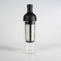 A black colored Hario filter-in coffee brew bottle that has a glass see-through bottom.