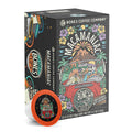The front of the Bones Coffee Company Macamaniac 12 Count Bones Cups box. Its flavor is a coconut and macadamia nut, and it has a skeleton wearing a cap driving a red car sipping out of a coconut with an erupting volcano behind it on the art.