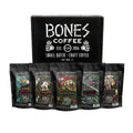 Five four ounce packs of coffee. From left to right their names are Costa Rica, Sumatra, Ethiopia, Colombia, Guatemala. There is a box behind it featured the Bones Coffee Company logo.